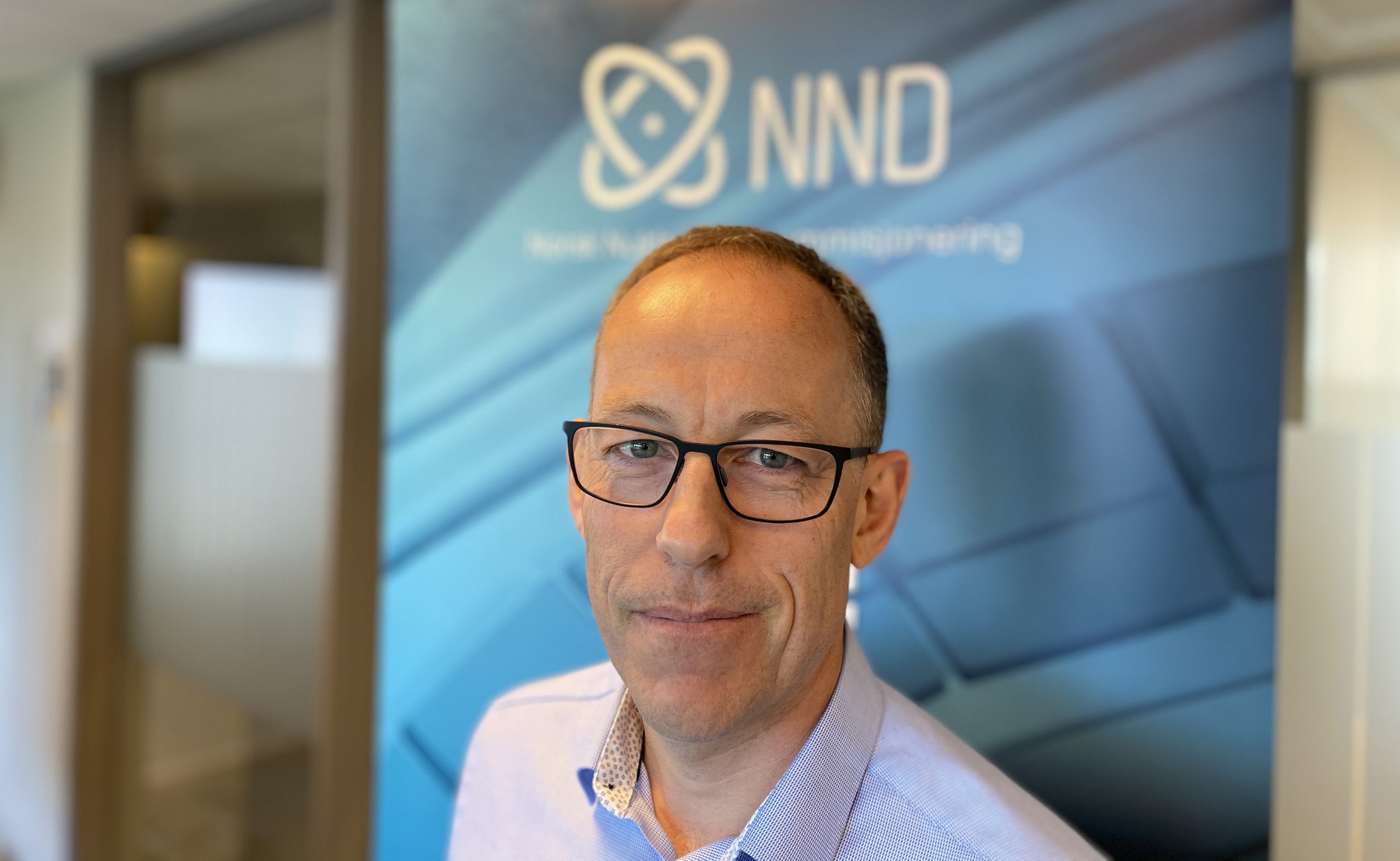 Profilbilde av Ole Jacob Ottestad | Ansatt i NND. Blå roll-up med NND-logo i bakgrunnen.
